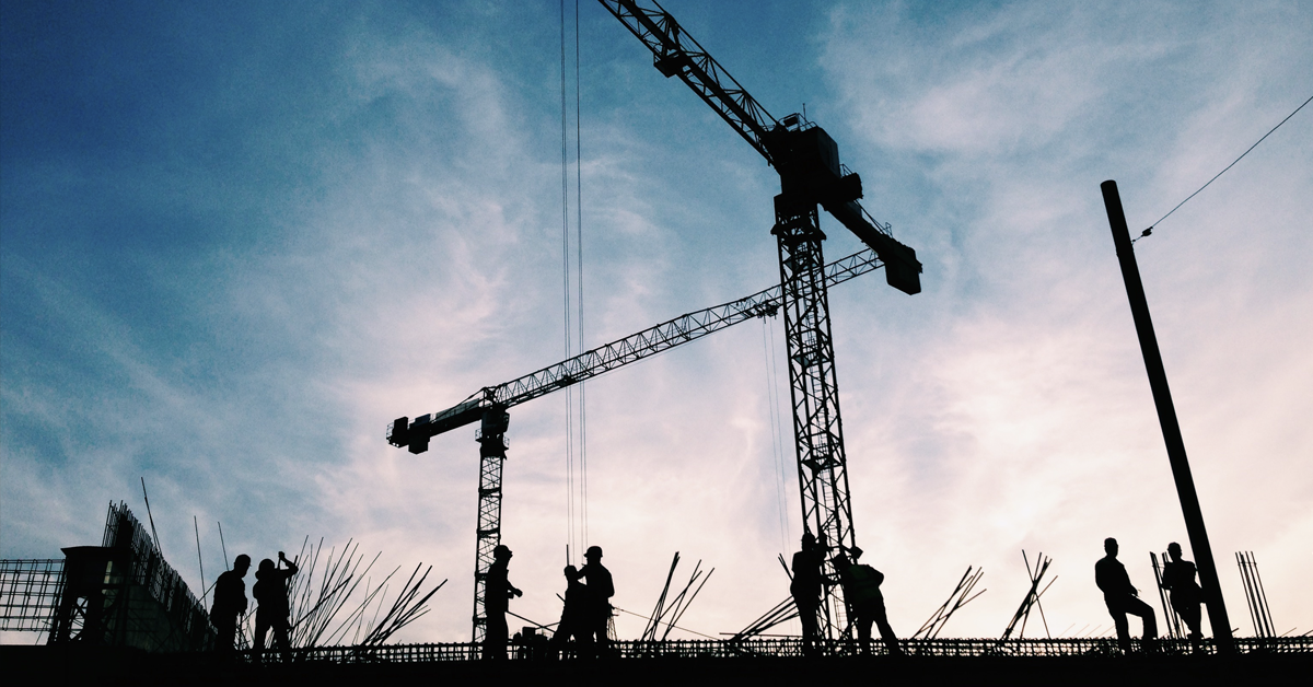 construction workers silhouette on blue sky.