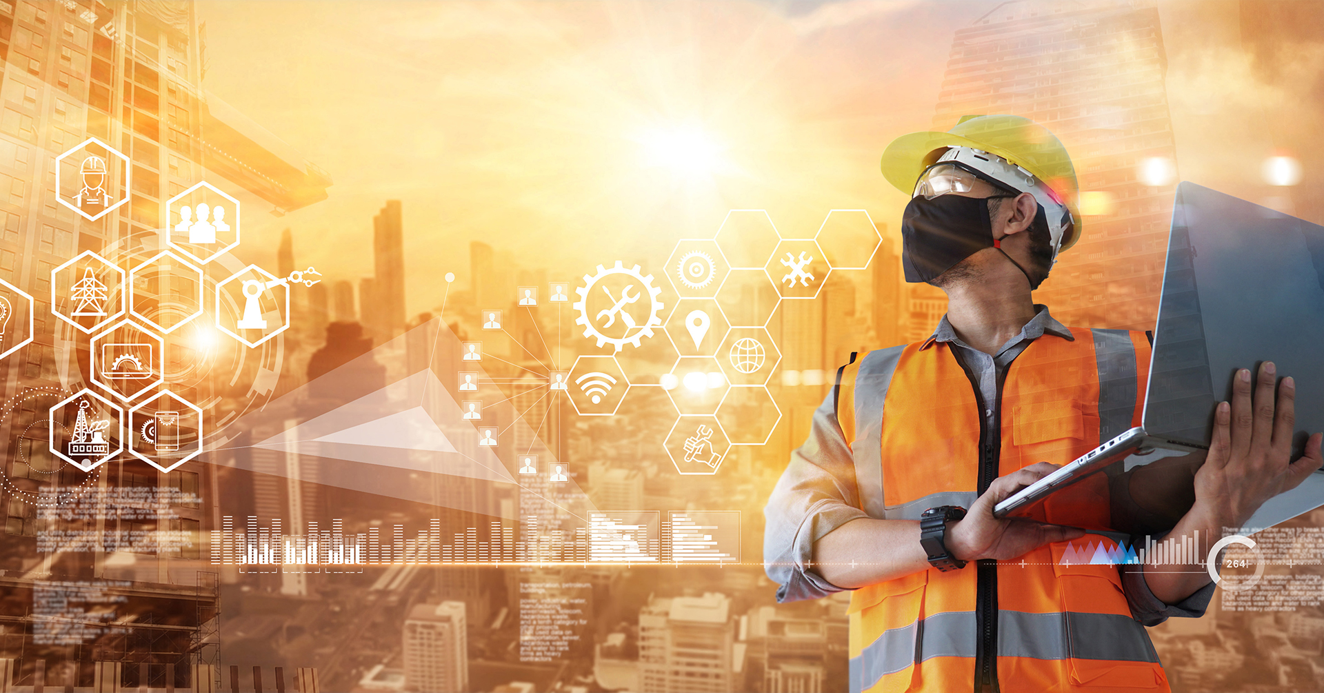 Man construction worker wearing a mask while holding a computer.