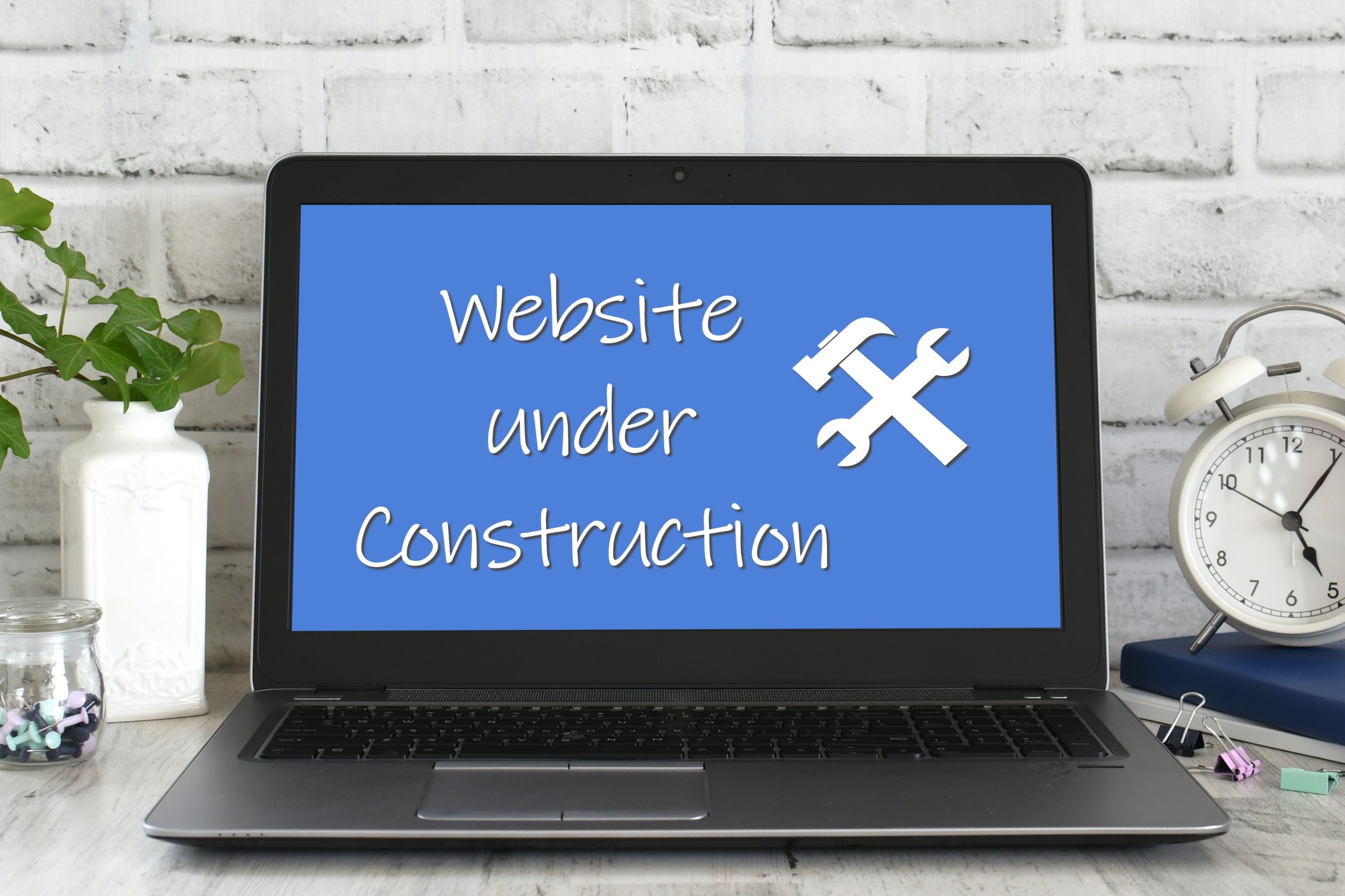 Website under Construction on screen of laptop computer on a desk in a bright minimal modern office