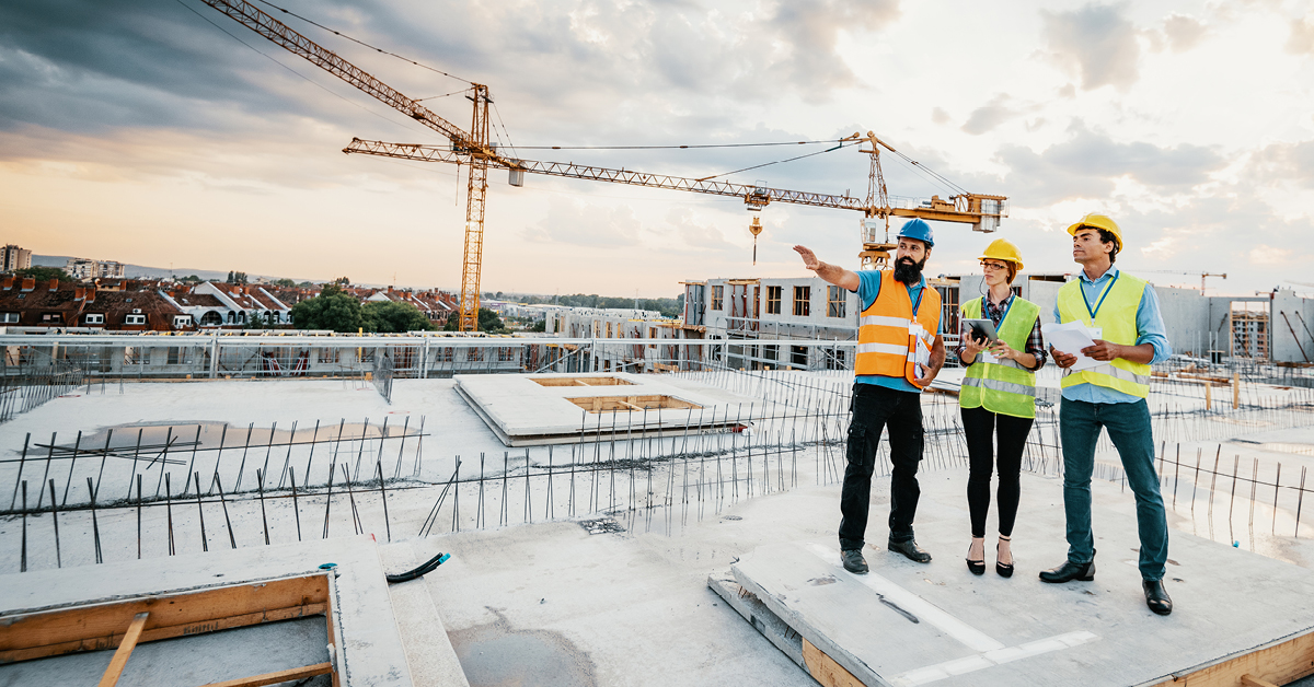 Group of construction workers point out at horizon