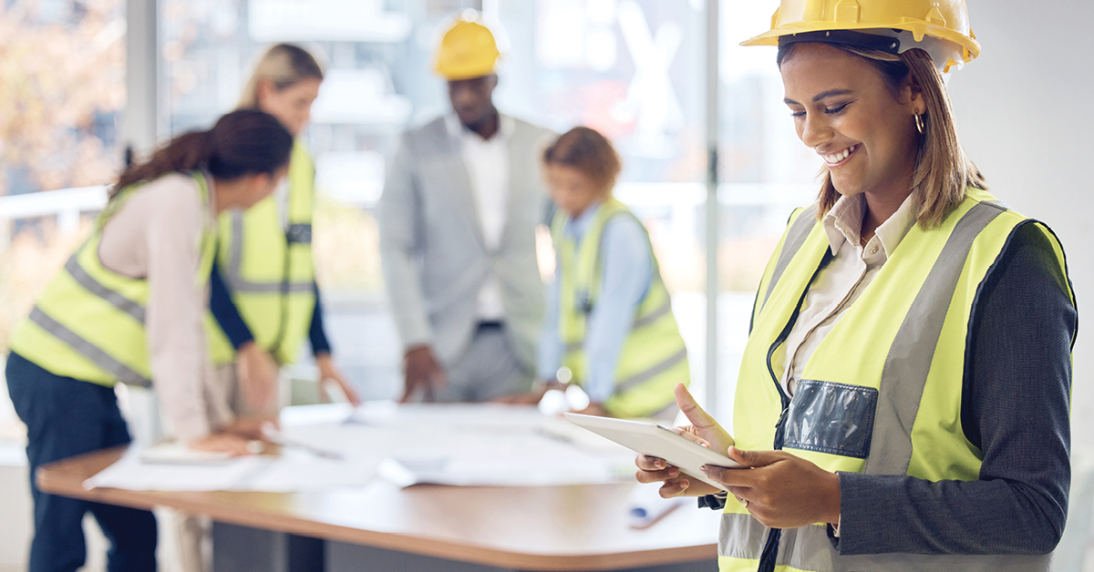 Construction professionals discussing over blueprint, symbolizing project sourcing