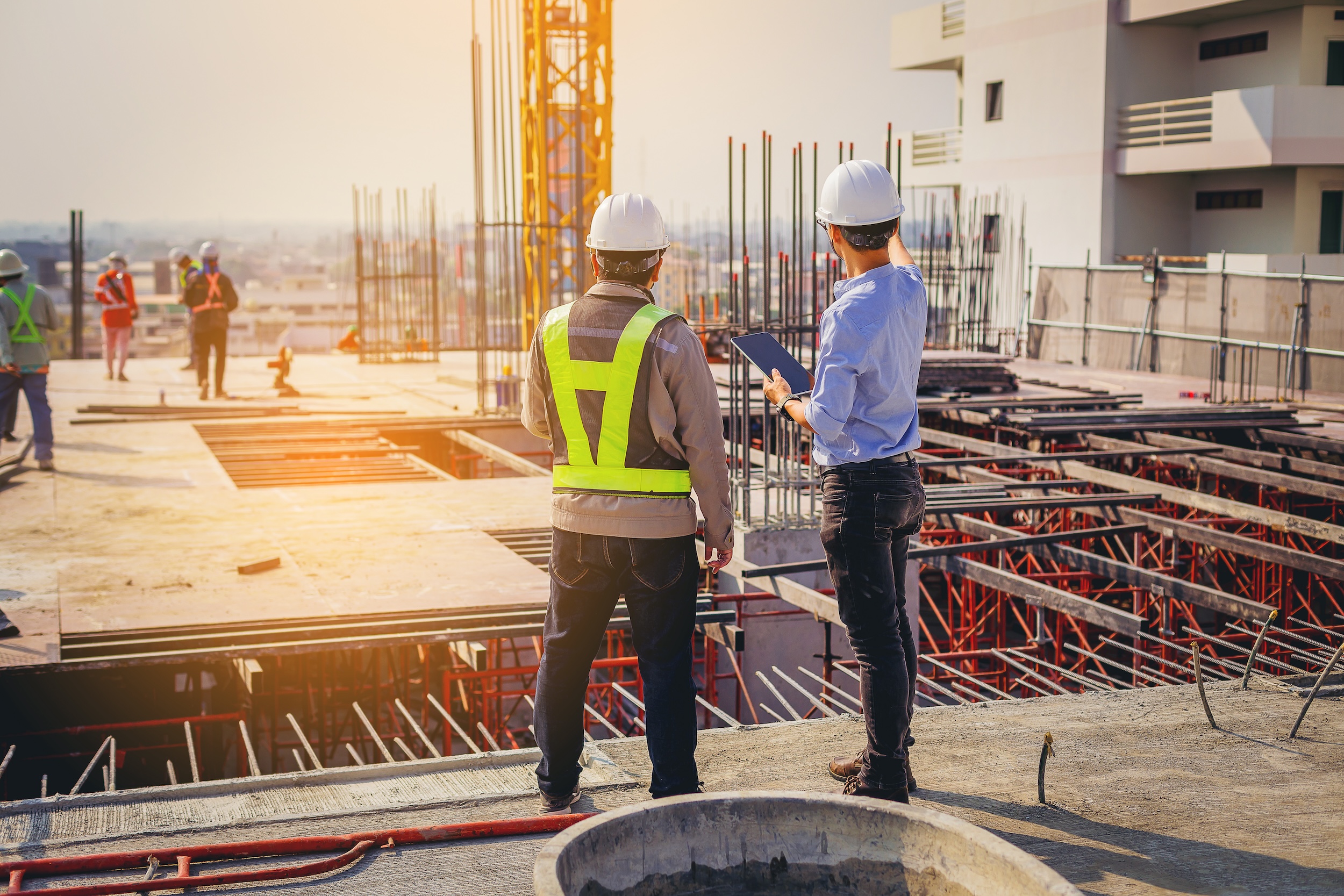 Structural Engineer And Foreman Worker With Touch Pad Discuss, Plan Working For The Outdoors Building Construction Site.