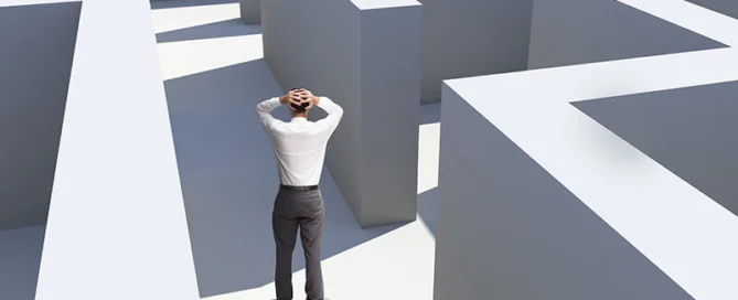 Rear View Of Businessman Standing In Maze Being Captured